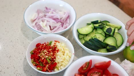 a sequence of fresh vegetables and spices being arranged on a kitchen counter, highlighting vibrant colors and textures