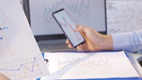 hombre comparando y analizando gráficos digitales y dibujados.