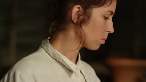 Dreamy-girl-thinking-about-something-in-pottery.-Woman-walking-in-studio