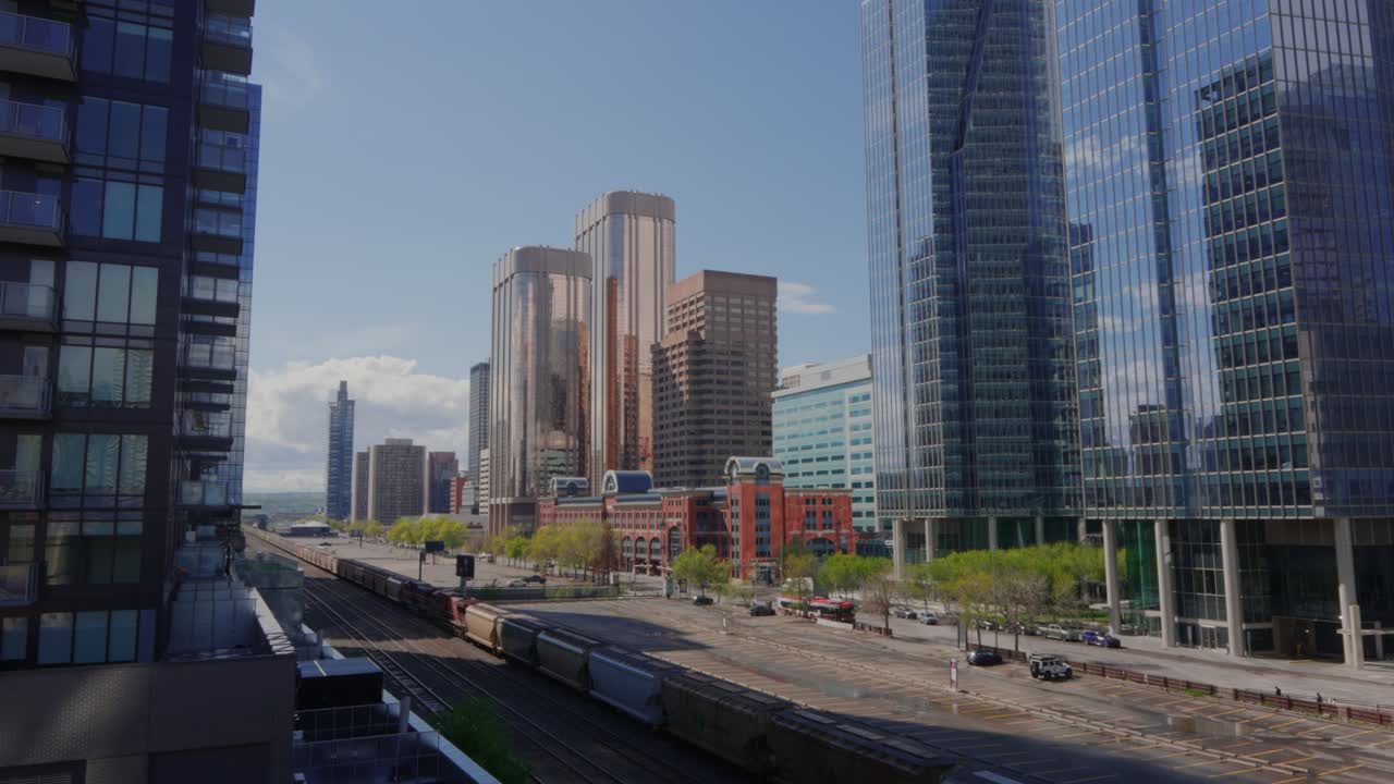 Paesaggio urbano del centro di Calgary che mostra moderni grattacieli e un lungo treno di passaggio