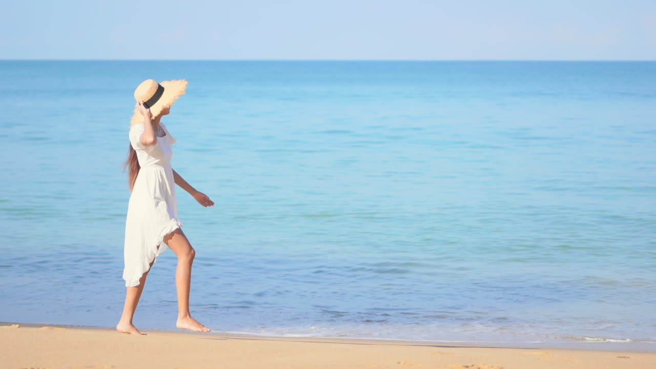 따뜻한 모래사장을 따라 걷는 행복한 여자