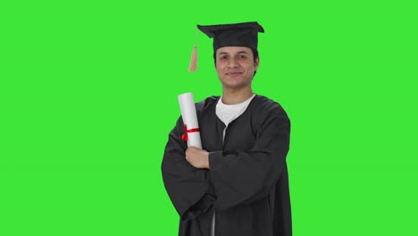 retrato de un feliz estudiante de posgrado indio de pie con las manos cruzadas pantalla verde