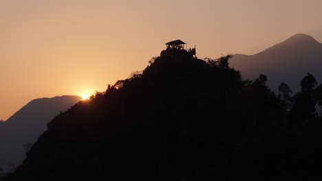 sunrise on a mountaintop with a hut