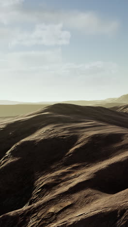 vast desert landscape: rolling red hills under a clear sky