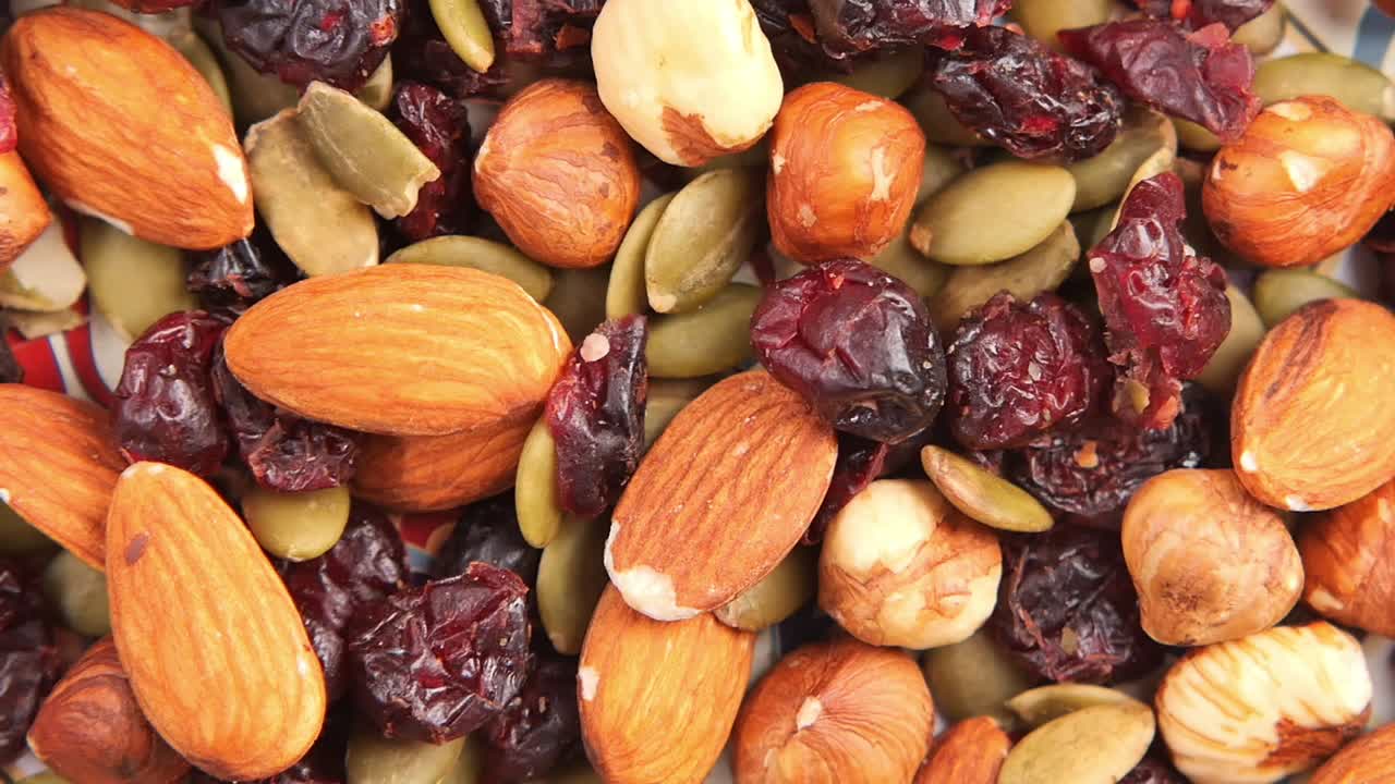 Nærbilde av blandede nøtter og tørket frukt som faller