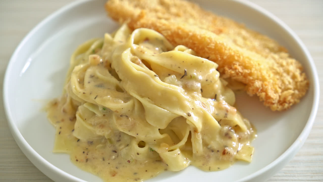 생선 튀김을 곁들인 홈메이드 페투치니 파스타 화이트 크림 소스