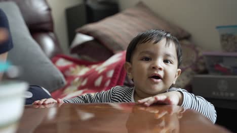 Adorable-8-Month-Old-Holding-Onto-Table-Edge-And-Walking-Around-Indoors