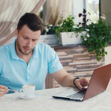 Man-Using-Laptop-Drinks-Coffee