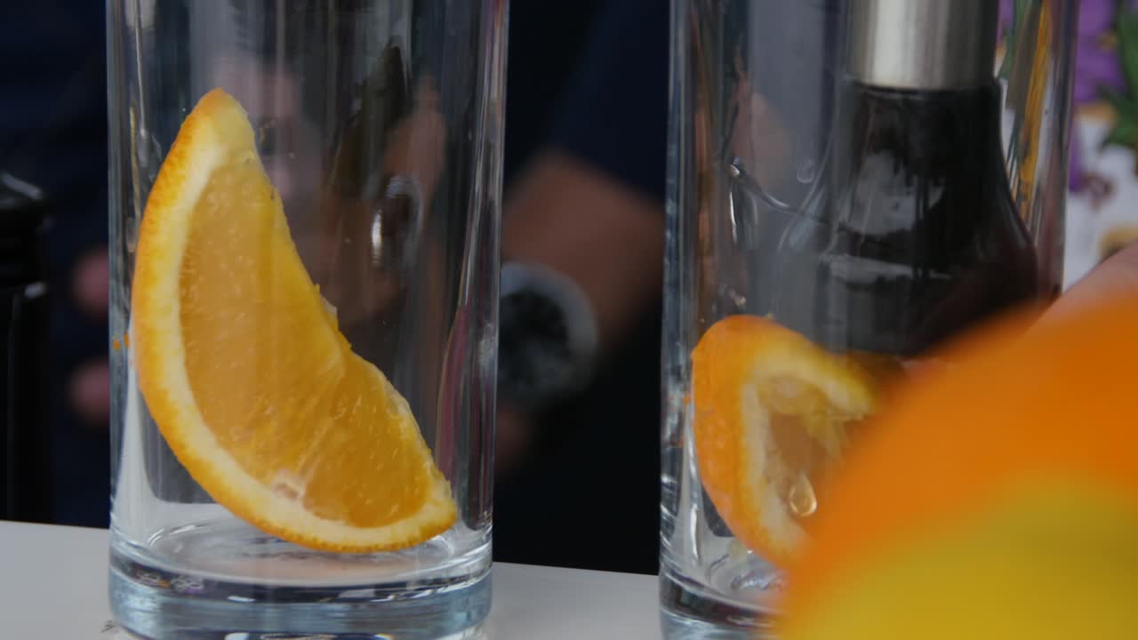 Barman che prepara un cocktail con una fetta d'arancia