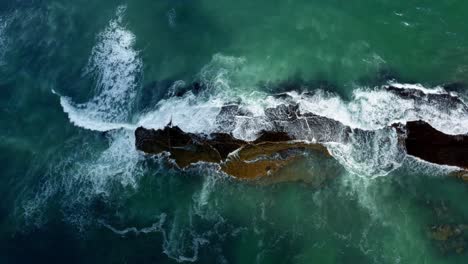 Hermoso-Ojo-De-Pájaro-En-La-Parte-Superior-De-Un-Dron-Aéreo-De-Olas-Aplastando-Una-Roca-Negra-En-La-Playa-De-Sibauma-Creando-Una-Piscina-Natural-Durante-La-Marea-Baja-Cerca-De-Pipa-En-El-Norte-De-Brasil