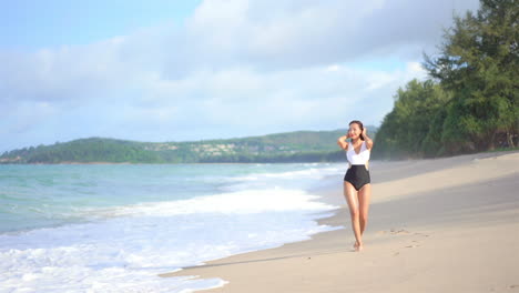 Sexy-young-woman-walks-on-beach-wearing-black-and-white-swimsuit