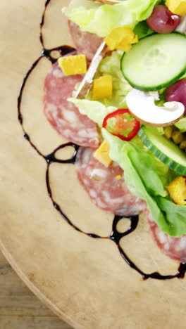 carne y ensalada en un plato de madera