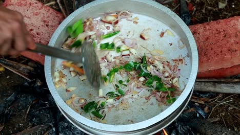 curry-leaves-and-coconut-are-mixed-in-the-onion-,-black-clam-masala-curry,-traditional-outdoor,-black-clams-cooking,-pollution-,-masala-,-brick