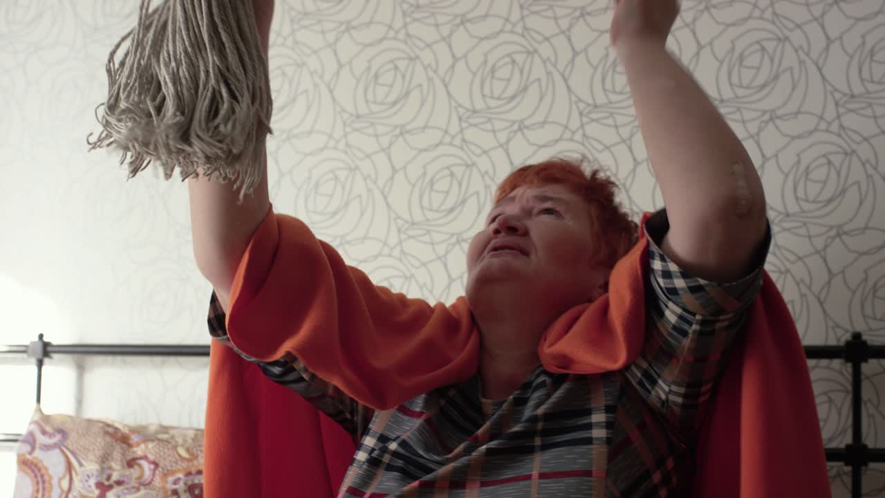 mujer anciana luchando para limpiar
