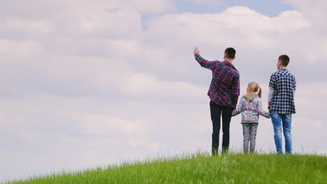 Drei-Kinder---Zwei-Teenager-Und-Ein-Mädchen-Von-6-Jahren-Stehen-Auf-Einem-Grünen-Hügel-1