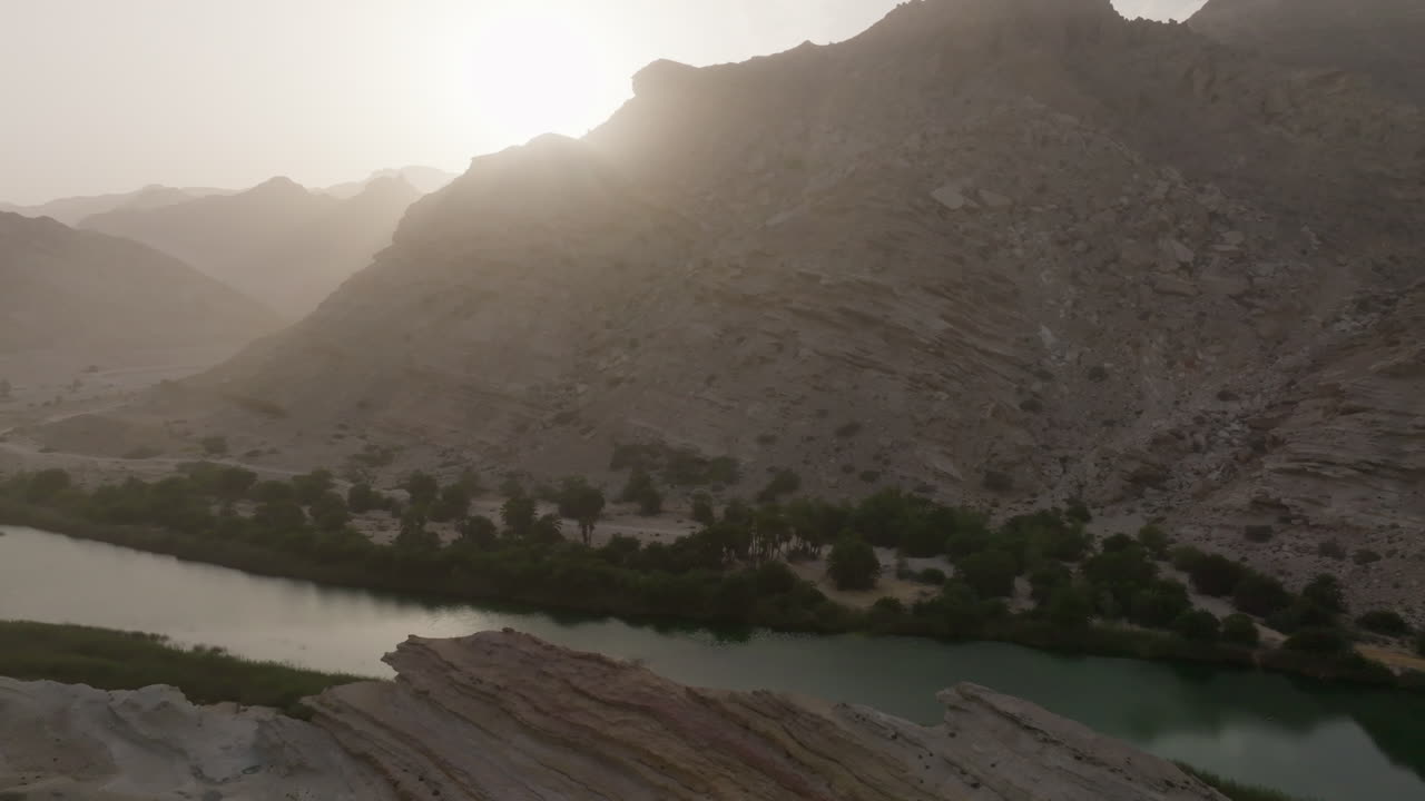 An oasis or wadi near the coast of oman, showcasing rocky hills and water, aerial view