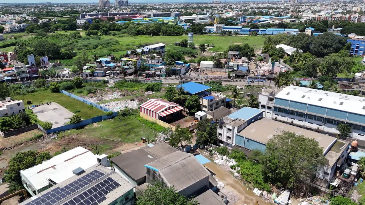 An aerial view of a multi-purpose sports complex, featuring a circular skating area a net-enclosed cricket practice ground