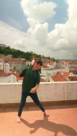 girl dancing on rooftop with headphones