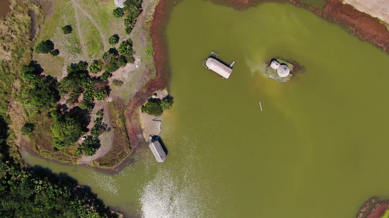 페루의 아마존 낙원으로 가는 입구인 팅고 마리아 시에 있는 라구나 데 로스 밀라그로스 위로 축소되는 편안한 4k 항공 주간 비디오