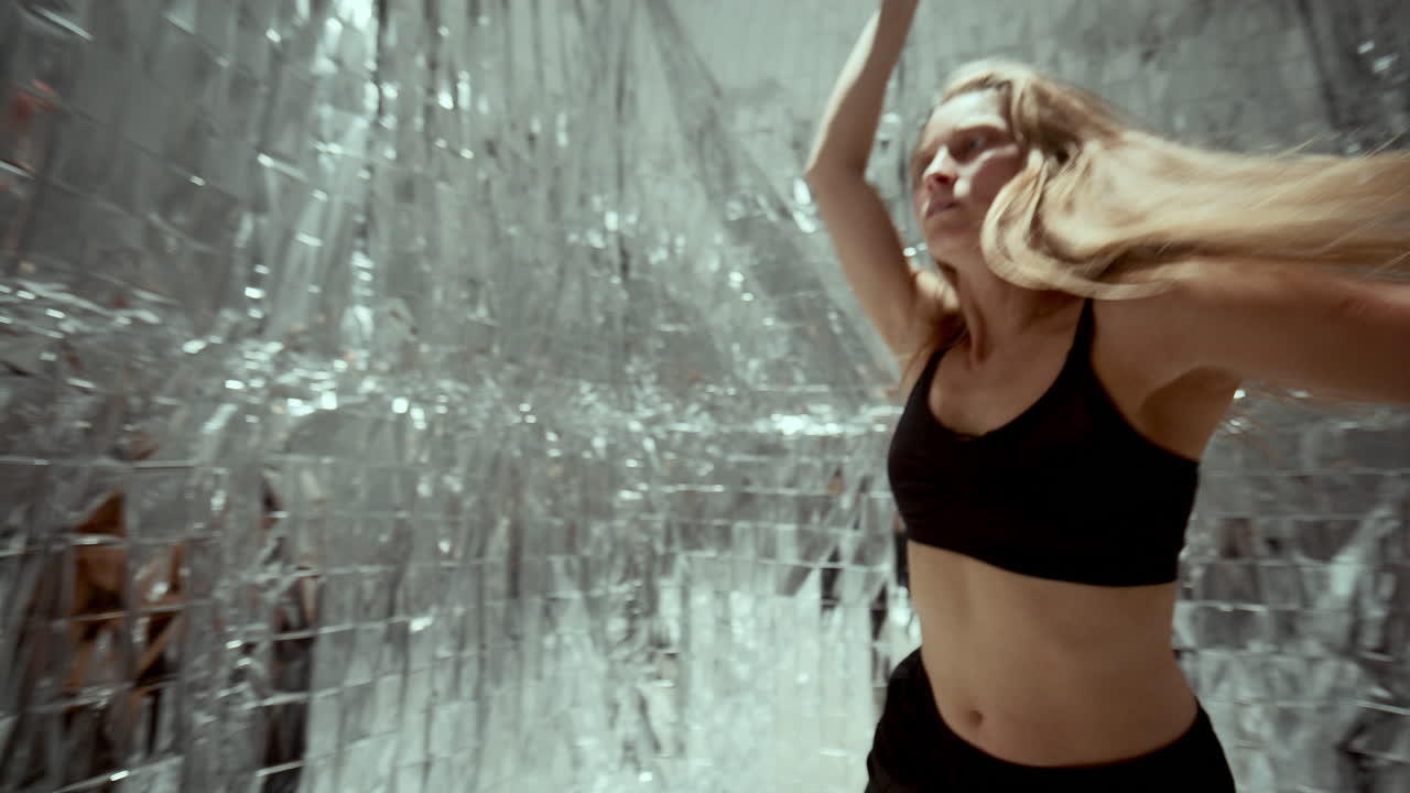 Inspired Female Dancer Performing Contemporary Choreography in Metallic Room