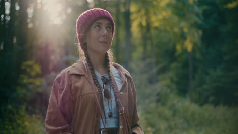 female hiker using binocular standing in woods