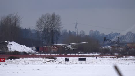 small cessna airplane taking off from snow covered local airfield