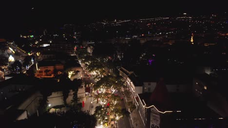 Luces-Navideñas-Decorativas-En-árboles-Con-Una-Calle-Idílica-En-Funchal,-Antena