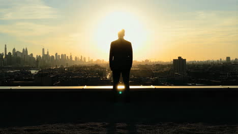 man on a rooftop at sunset overlooking the city