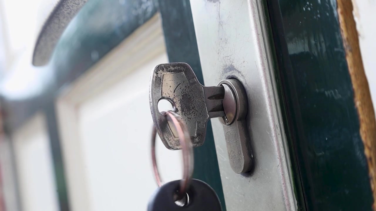 Video putting key inside a front door lock and turning it.