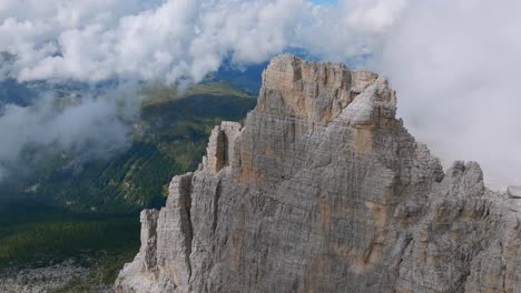 tiro de drones en órbita de la montaña rocosa brenta con una cordillera neblinosa en el fondo a la luz del sol