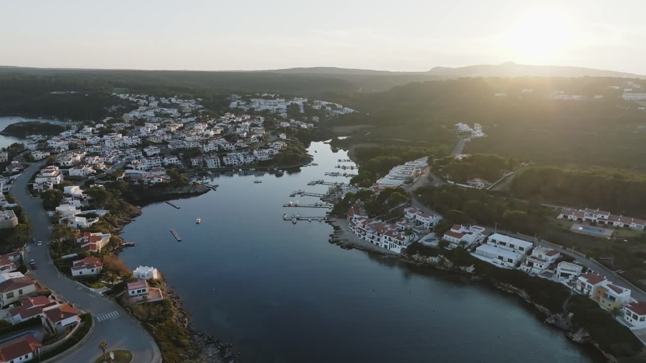 A cinematic aerial view of Na Macaret, Menorca, Spain at golden hour