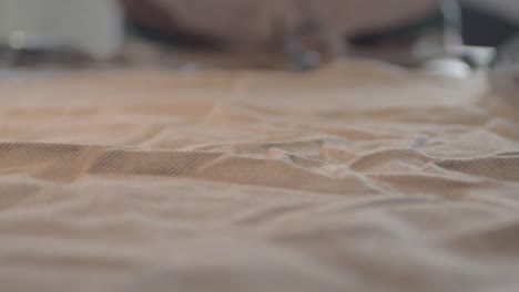 dressmaker picks up scissors to cut material