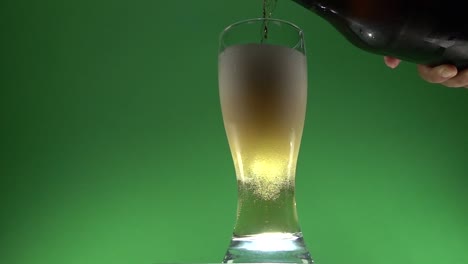 a hand pouring beer on a glass