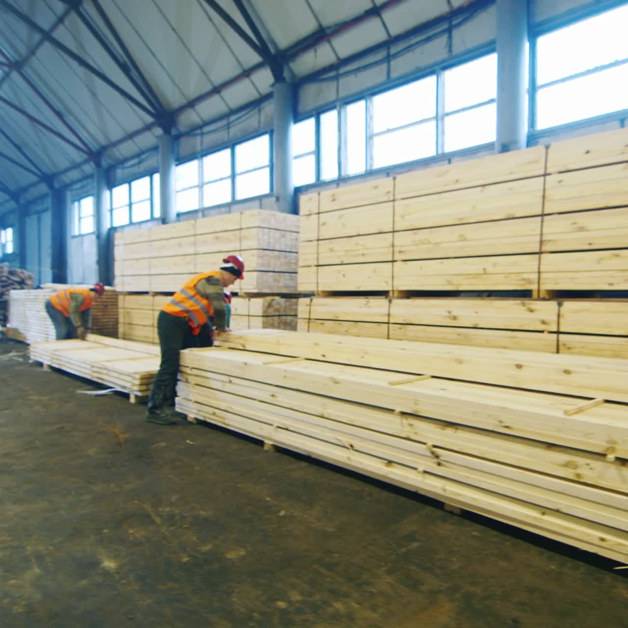 группа рабочих перемещает деревянные рейки на складе 3