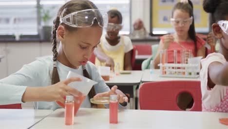 Focused-diverse-schoolgirls-doing-experiments-in-elementary-school-chemistry-class,-slow-motion