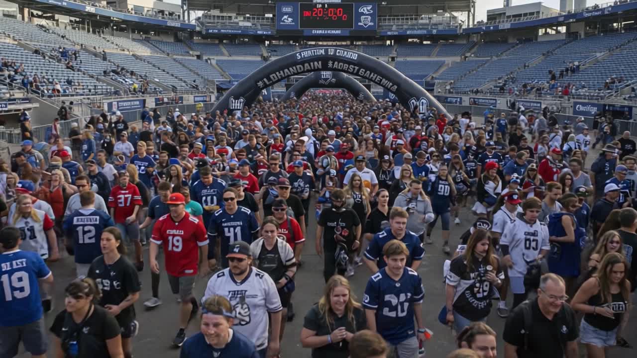 Fans Gather in Excitement for the Big Game: A Thriving Crowd of Supporters Walks Through the Entrance of the Stadium, Ready to Cheer for Their Teams