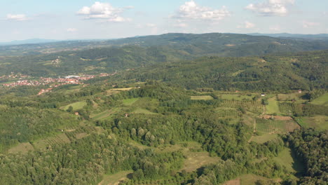 Low-flyover-amazing-green-forest-on-mountains-with-clouds-in-background