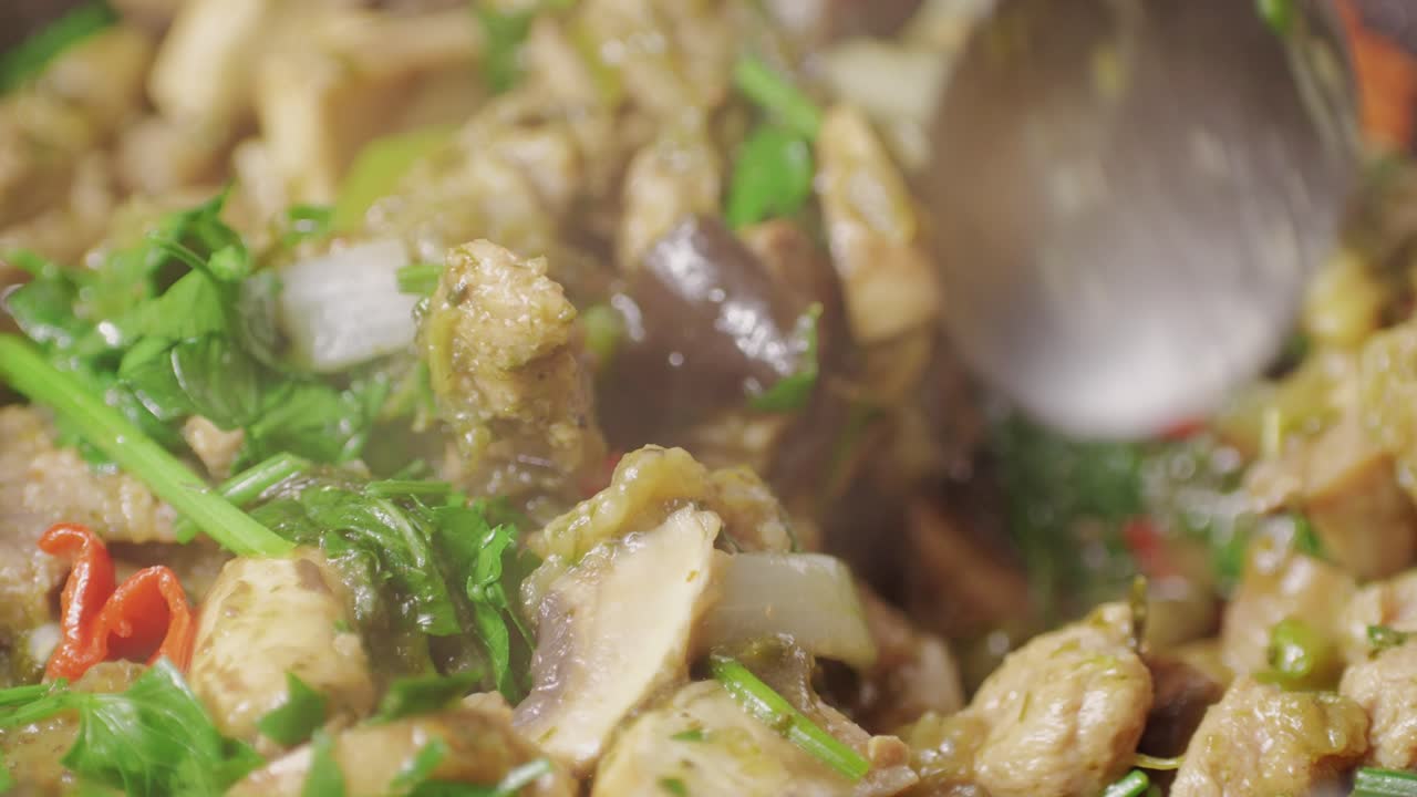 Chicken or pork stew with red and green pepper onion, and spices cooking in a frying pan. Traditional mexican cuisine, tacos preparation, ragout.