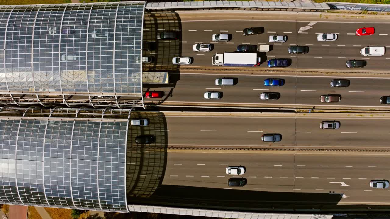 Top view, dense city traffic moving across expressway beneath transparent arcs