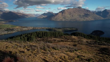 Queenstown-aerial-scenic-view,-town-and-lake-surrounded-by-mountain-peaks,-New-Zealand-landscape