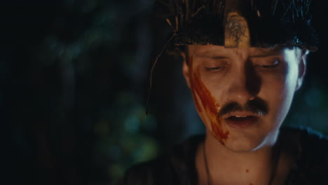 Man in Ritual Attire with Blood-like Markings