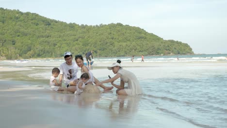 family sitting on a tropical beach in phu quoc, relaxing by the water with kids playing