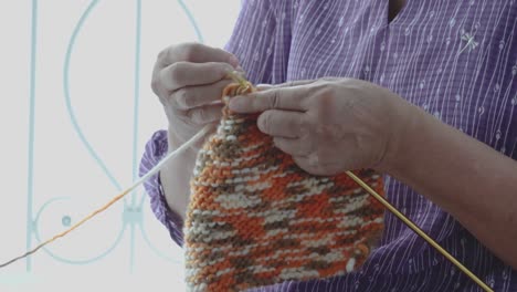 detail of the hands of an elderly person crocheting