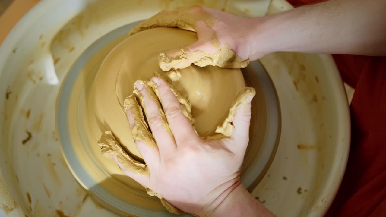 manos moldeando arcilla en una rueda de cerámica