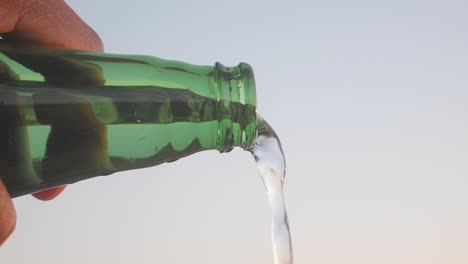 vertiendo agua de una botella verde