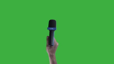 hand holding microphone for live press conference interview with green screen