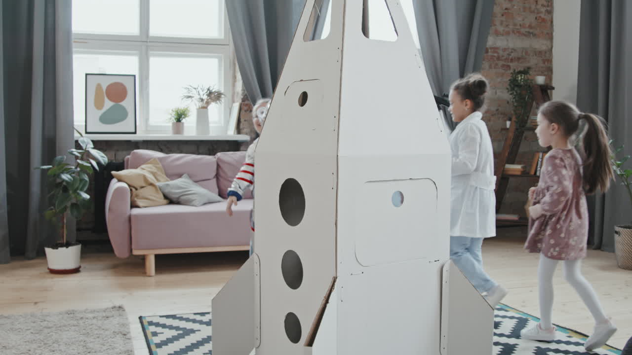 Group of Kids Running Around Cardboard Rocket Ship