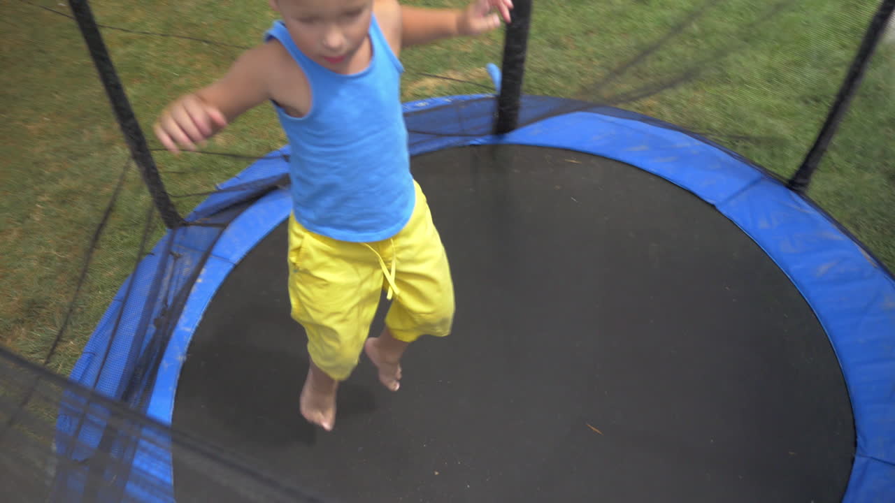 보호된 야외 트램프 안에 뛰어드는 아이