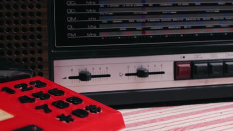 retro vintage red phone, telephone is displayed on a wooden desk, adding a nostalgic touch. man answer for call on button 90 phone.