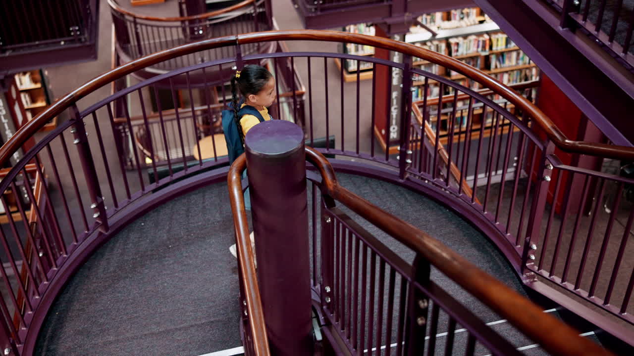 una chica subiendo las escaleras en una biblioteca.